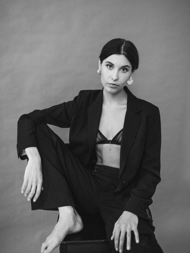 A founder at her desk, galleys and records spread in front of her, mid-thought.